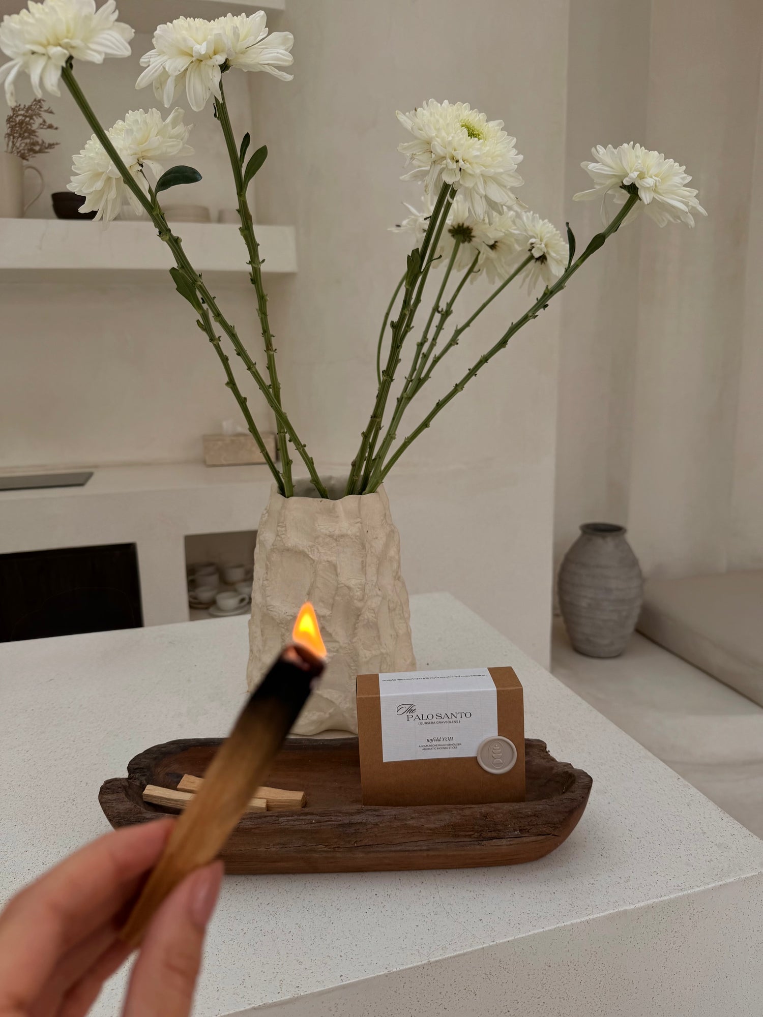 Palo Santo stick lit in beautiful, light room.