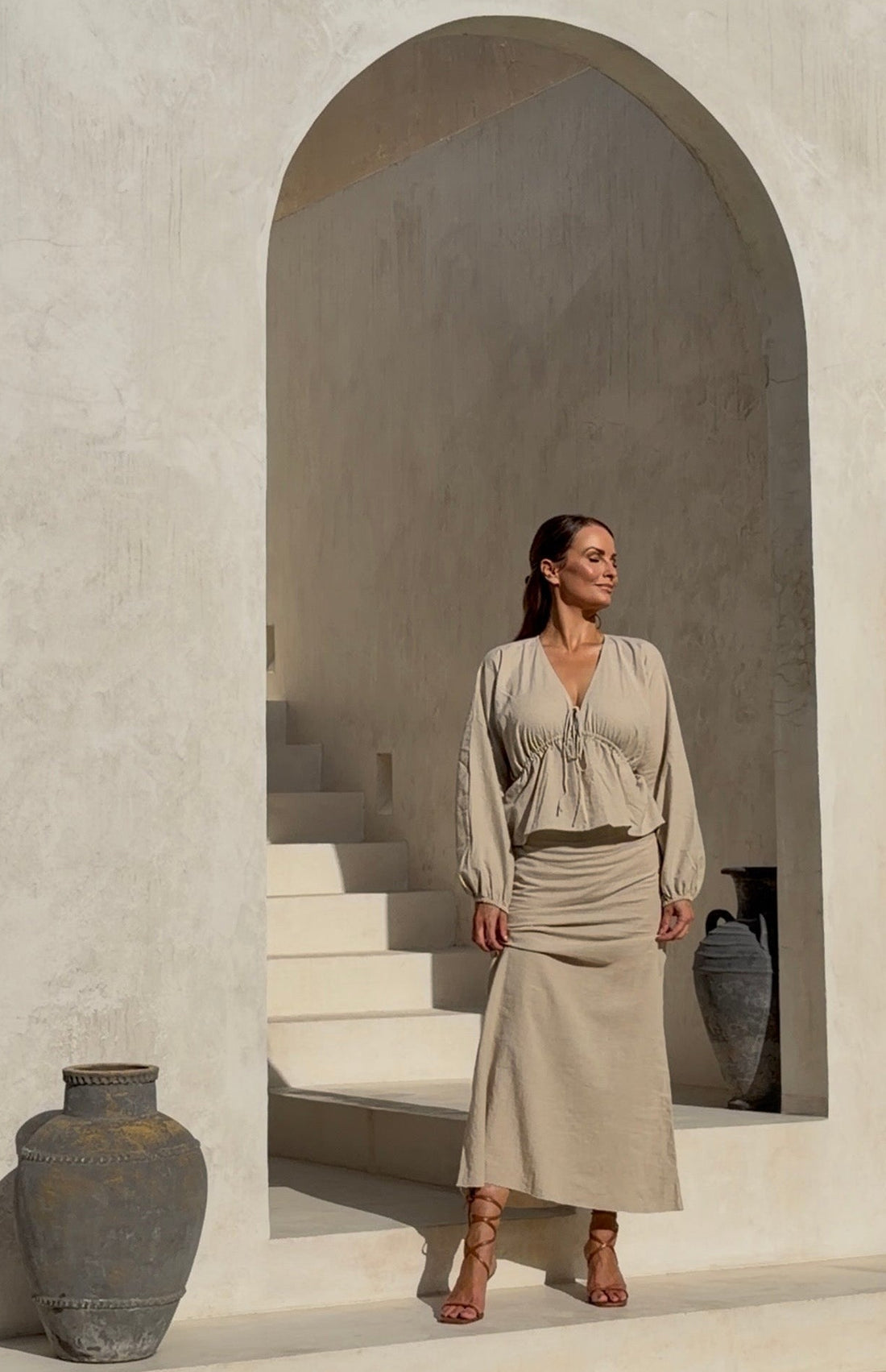 Full-length on-model view showcasing the un-dyed v neck blouse with its striking sculptural outline styled as a refined luxury ensemble.